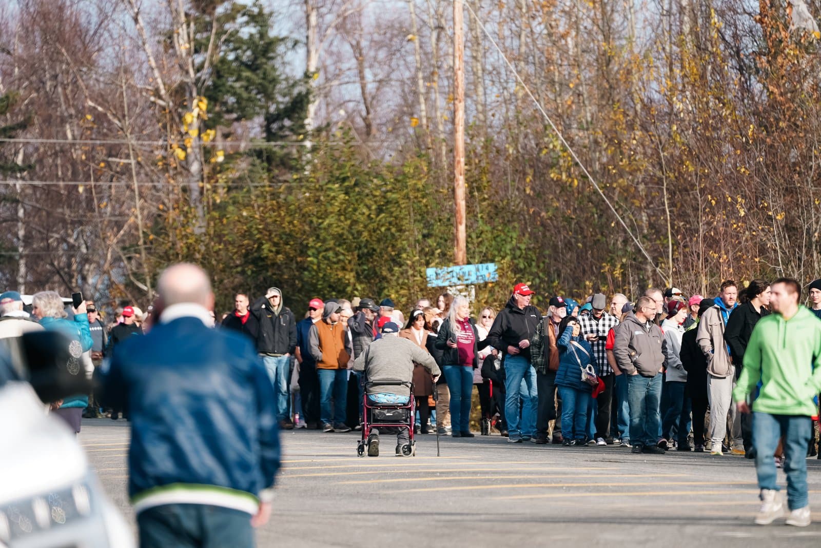 People wait near Church on the Rock in Wasilla on Oct. 13, 2026, for shuttles to Donald Trump’s event at the Menard Center.