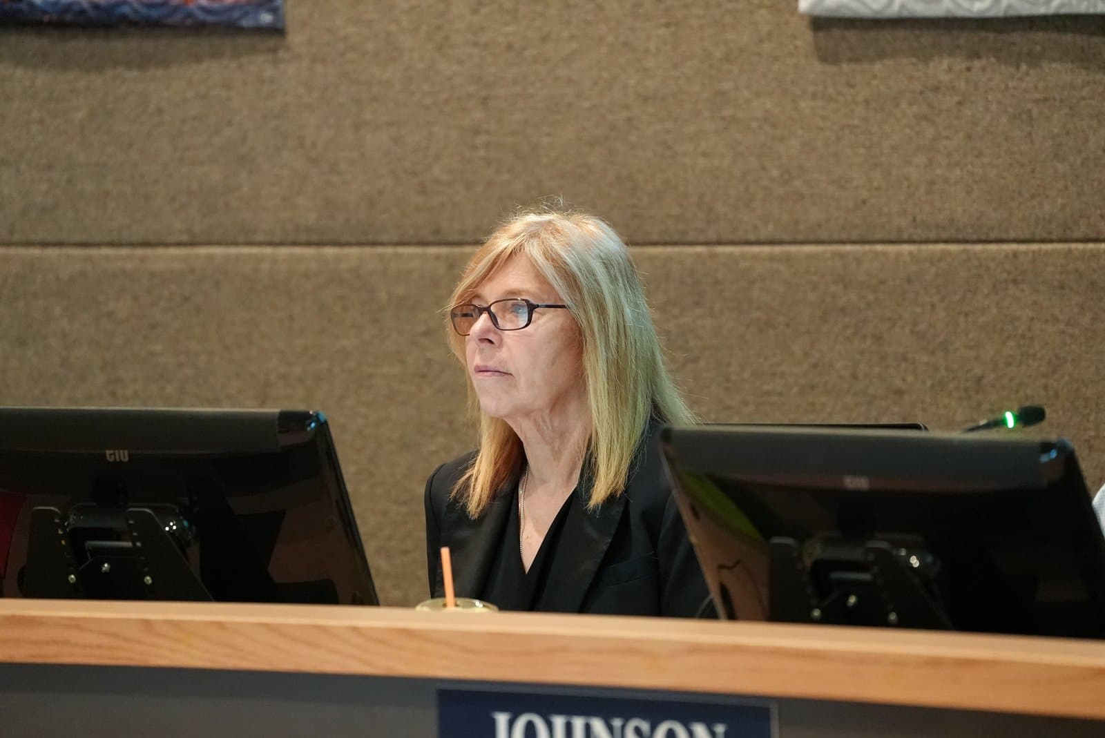 A woman sits at a desk with computer monitors during an Anchorage Assembly meeting held on June 23, 2026.