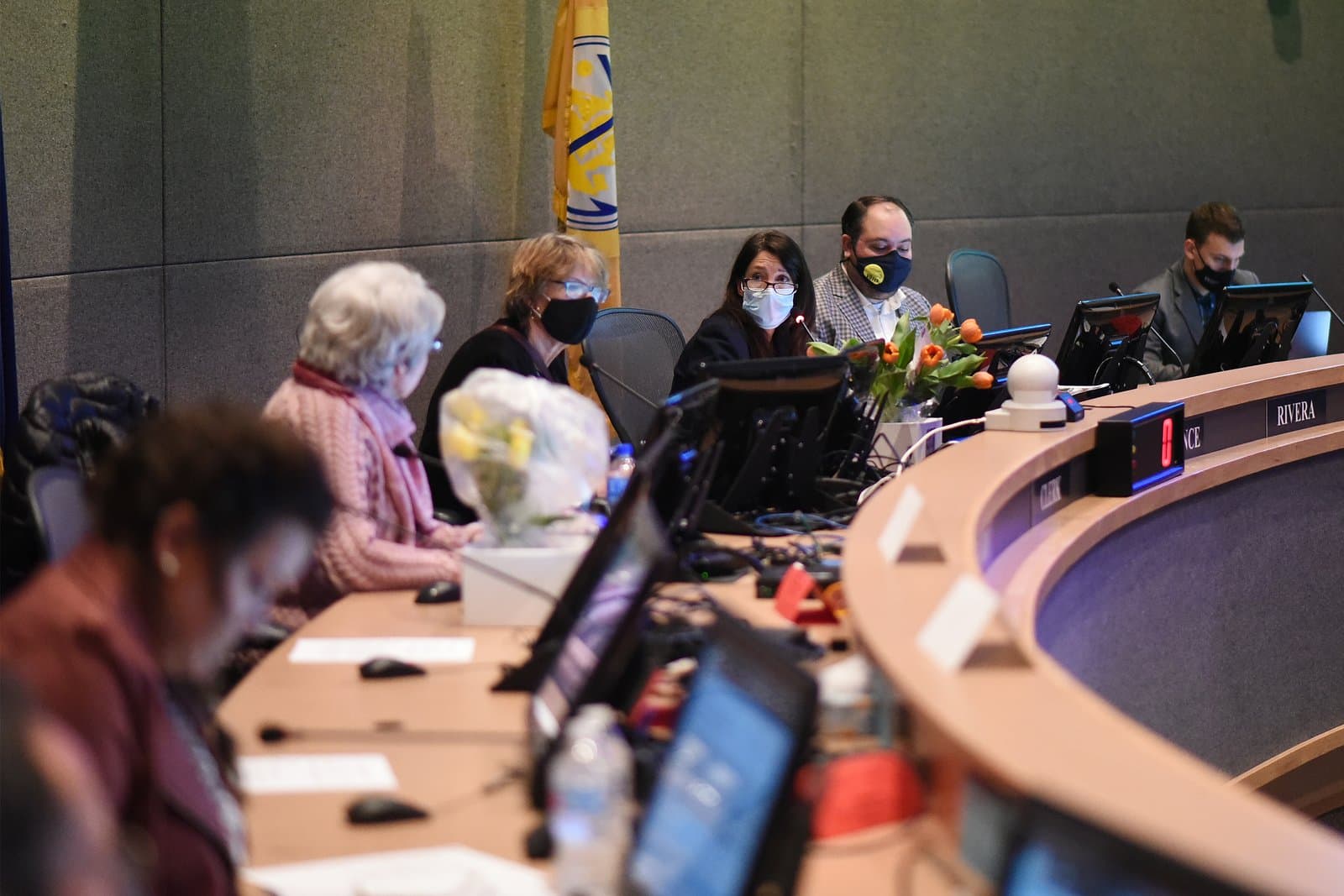 Members of the Anchorage Assembly sit at a curved desk during a public meeting held in Anchorage, Alaska, in October 2021.
