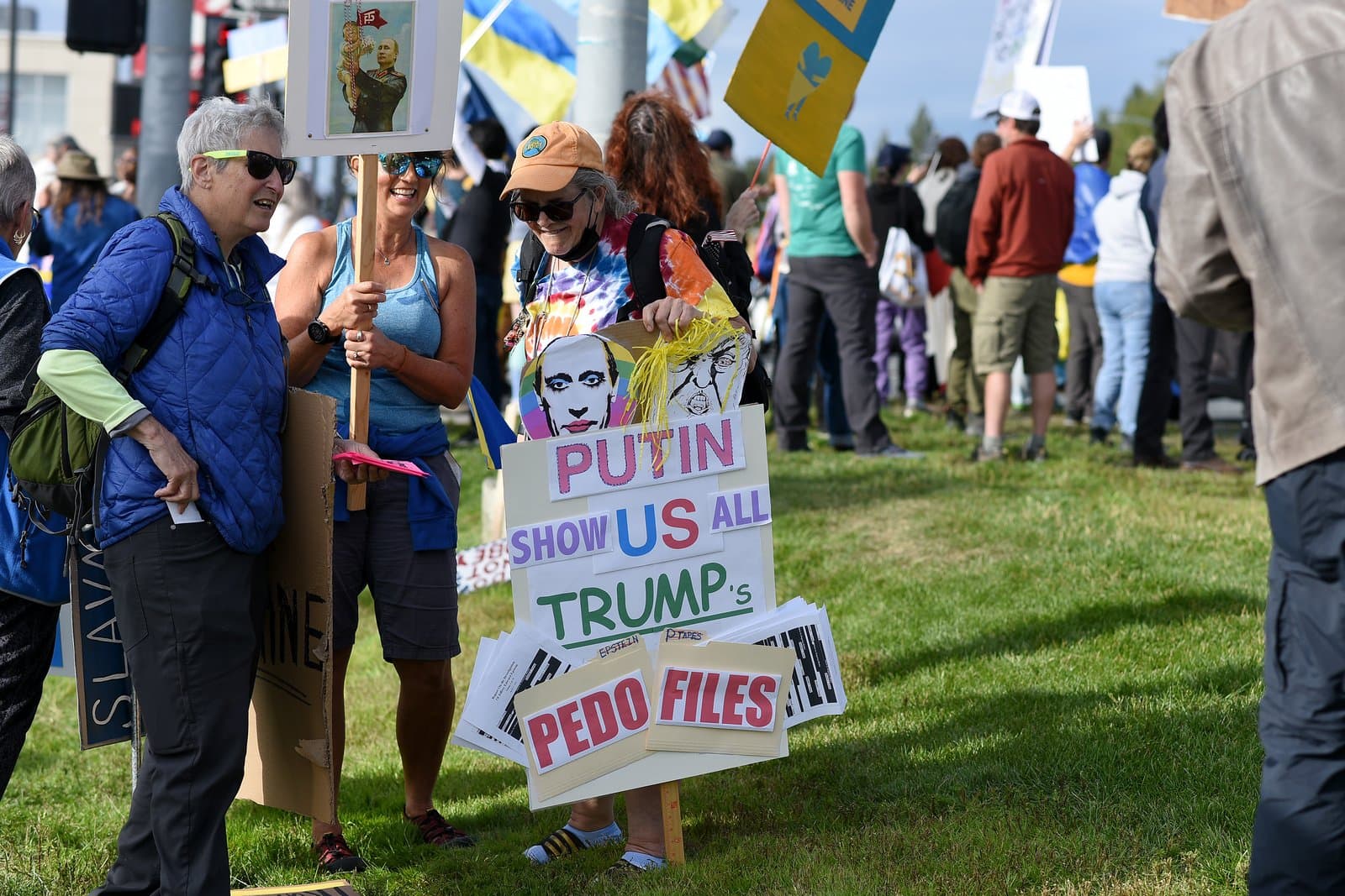 Protesters hold signs during a pro-Ukraine and anti-Trump rally held in midtown Anchorage on a sunny summer day in August 2025.