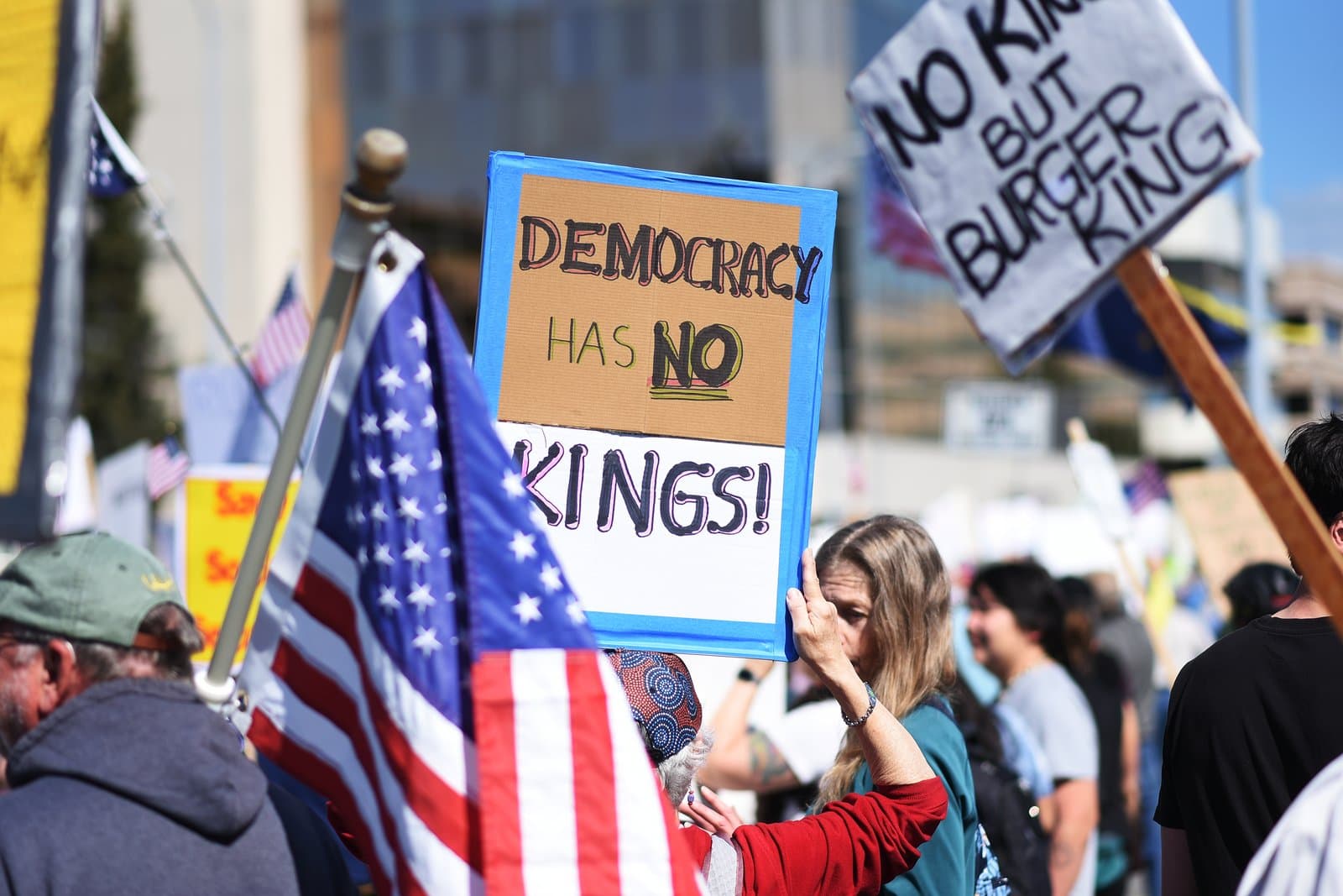 Protesters hold signs reading Democracy Has No Kings and No Kings But Burger King during a demonstration in Anchorage, Alaska.