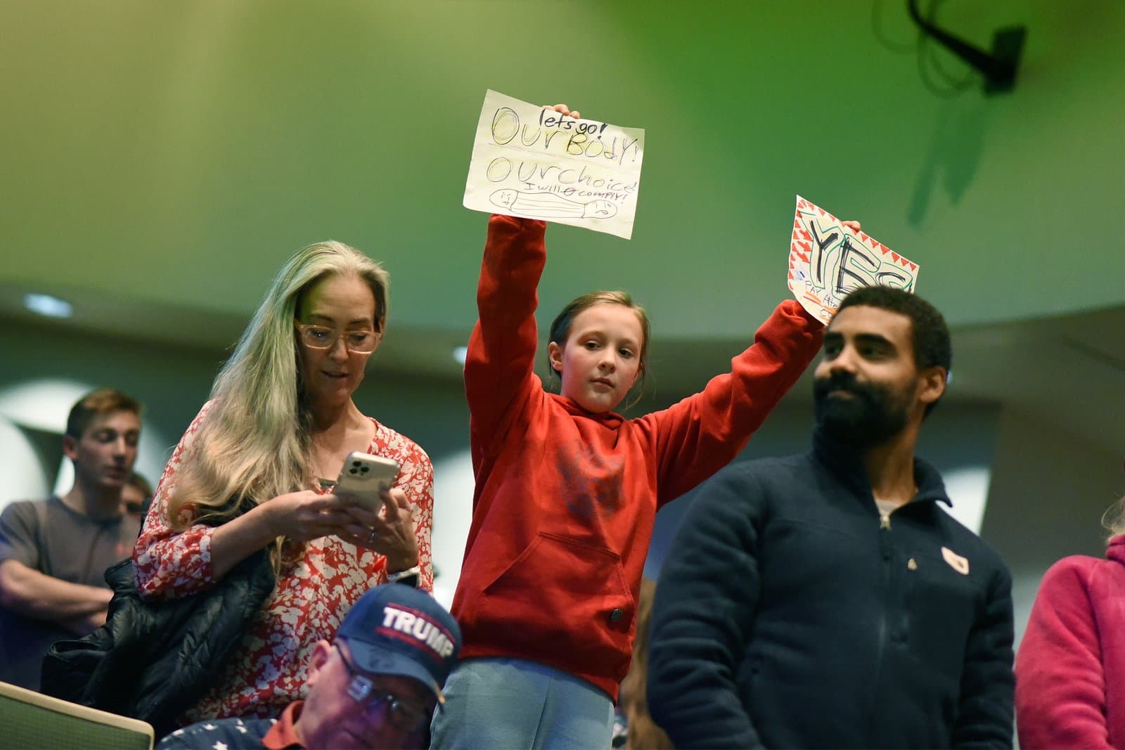 A young girl holds a sign reading Our Body Our Choice during an Anchorage Assembly meeting in October 2021.
