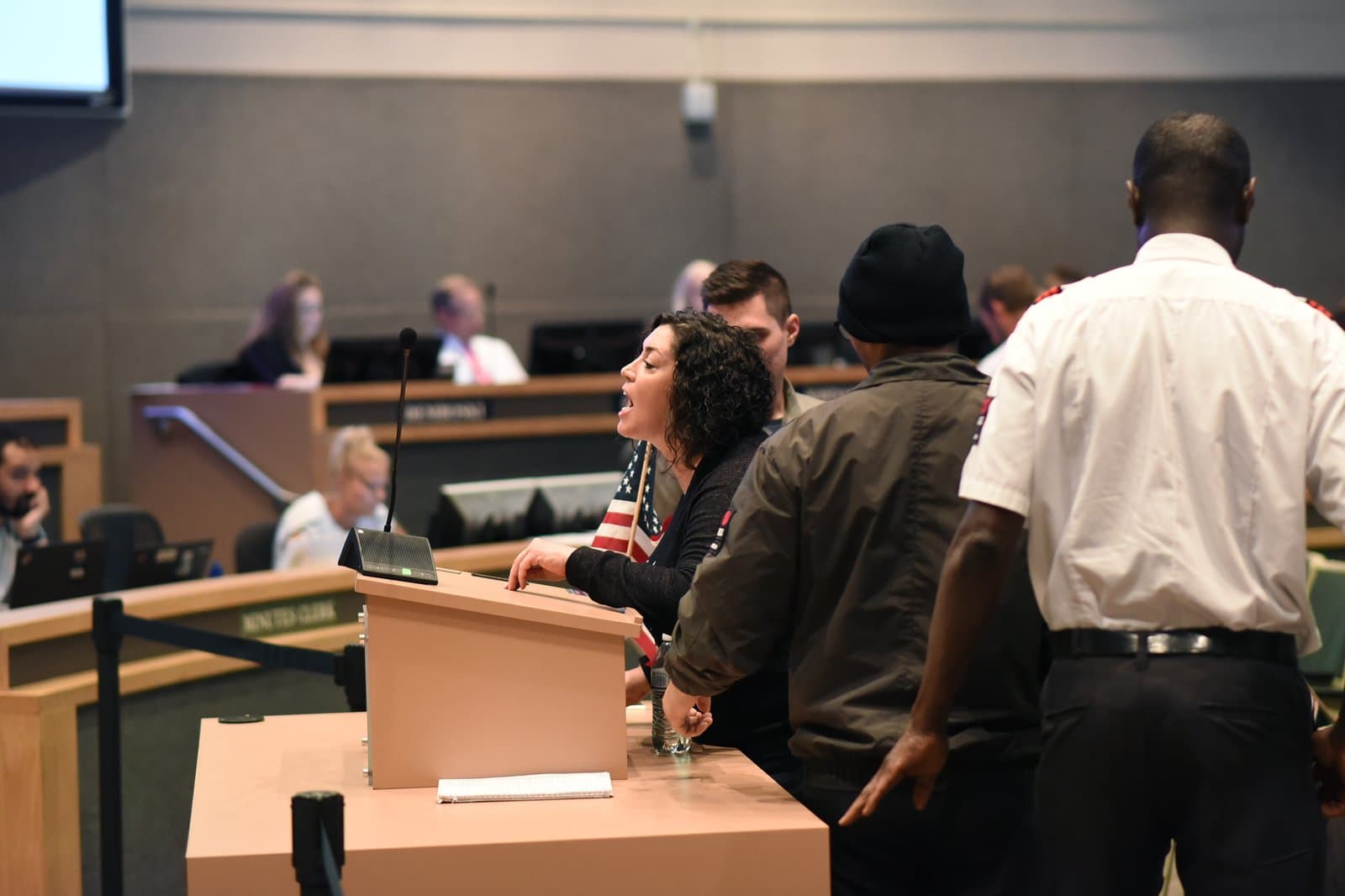 A woman speaks into a microphone at a podium during an Anchorage Assembly meeting held in July 2022 in Anchorage, Alaska.
