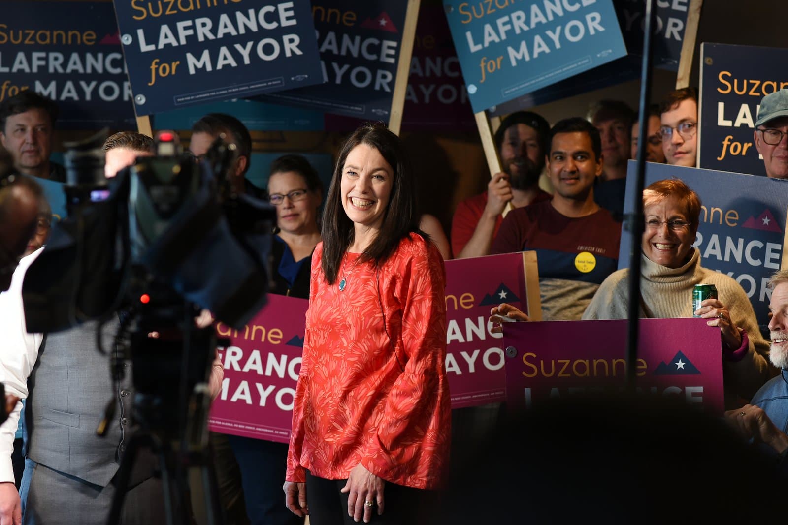 Suzanne LaFrance smiles while surrounded by supporters holding campaign signs during her mayoral election night party in Anchorage, Alaska.
