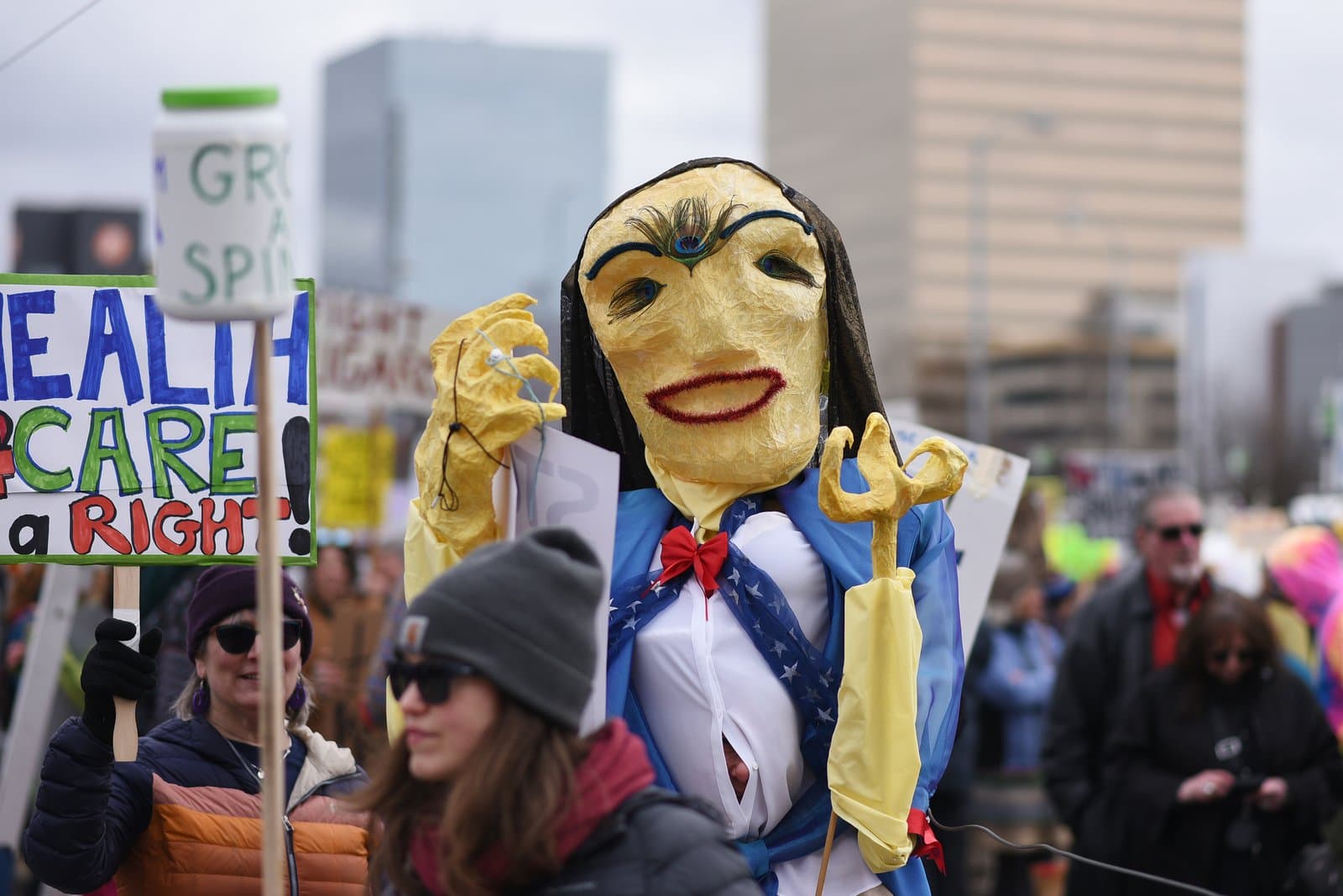 A protestor holds a large, yellow, hand-crafted puppet during a public demonstration in Anchorage, Alaska, on April 19, 2025.