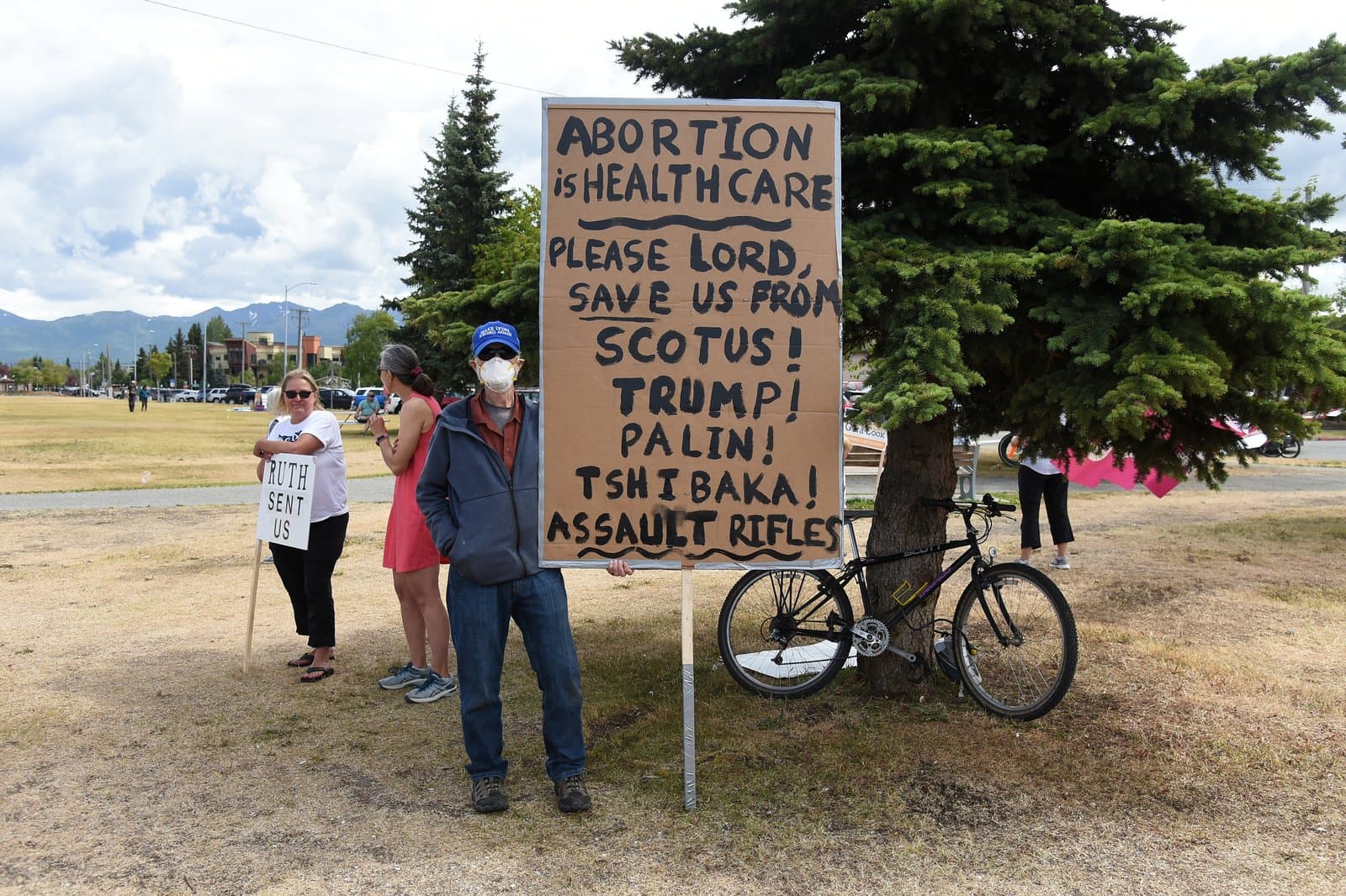 A protestor holds a sign criticizing political figures and policies during a Planned Parenthood rally in downtown Anchorage, Alaska, in July 2022.