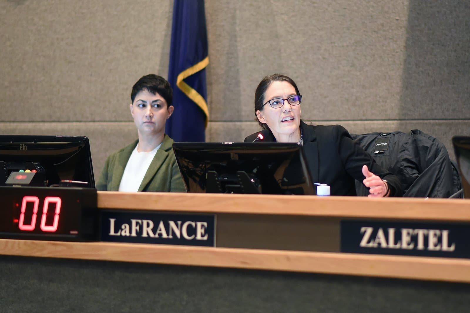 Assembly Member Suzanne LaFrance speaks during a public meeting in Anchorage, Alaska, with a colleague seated beside her.