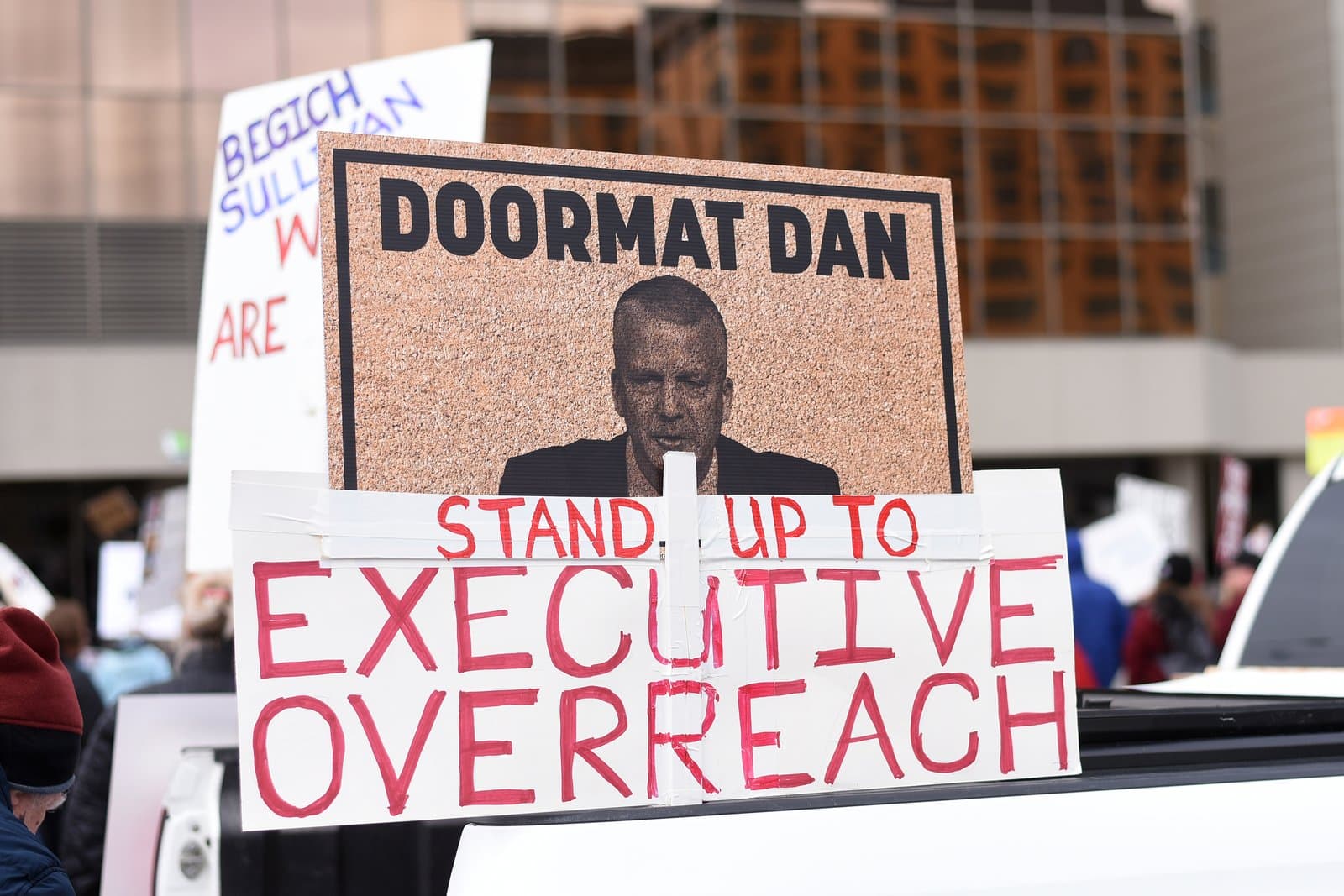 A protest sign reading Doormat Dan and Stand Up To Executive Overreach is held during a demonstration in Anchorage, Alaska.