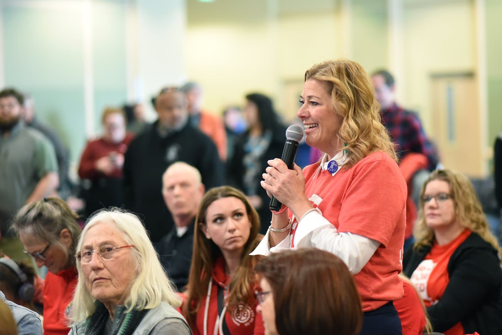 A woman speaks into a microphone while addressing an audience during the 2024 Anchorage Legislative Town Hall in Alaska.