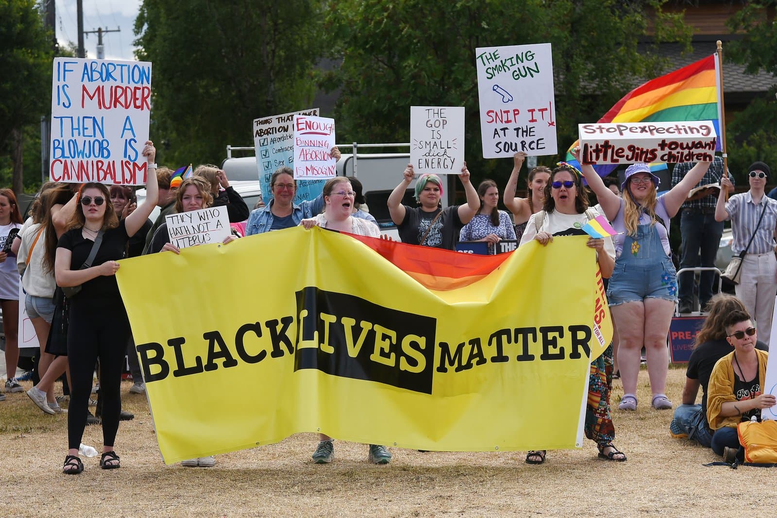 Protesters hold signs and a Black Lives Matter banner during a Planned Parenthood rally in downtown Anchorage, Alaska, on July 9, 2022.