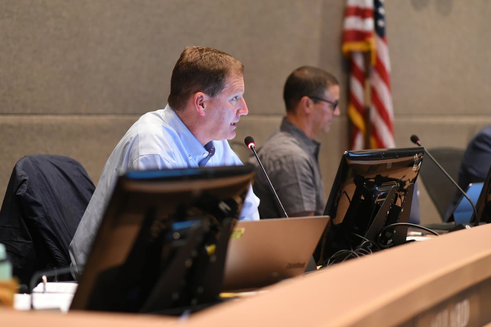 An Anchorage Assembly member speaks into a microphone during a public meeting held in Anchorage, Alaska, on July 12, 2022.