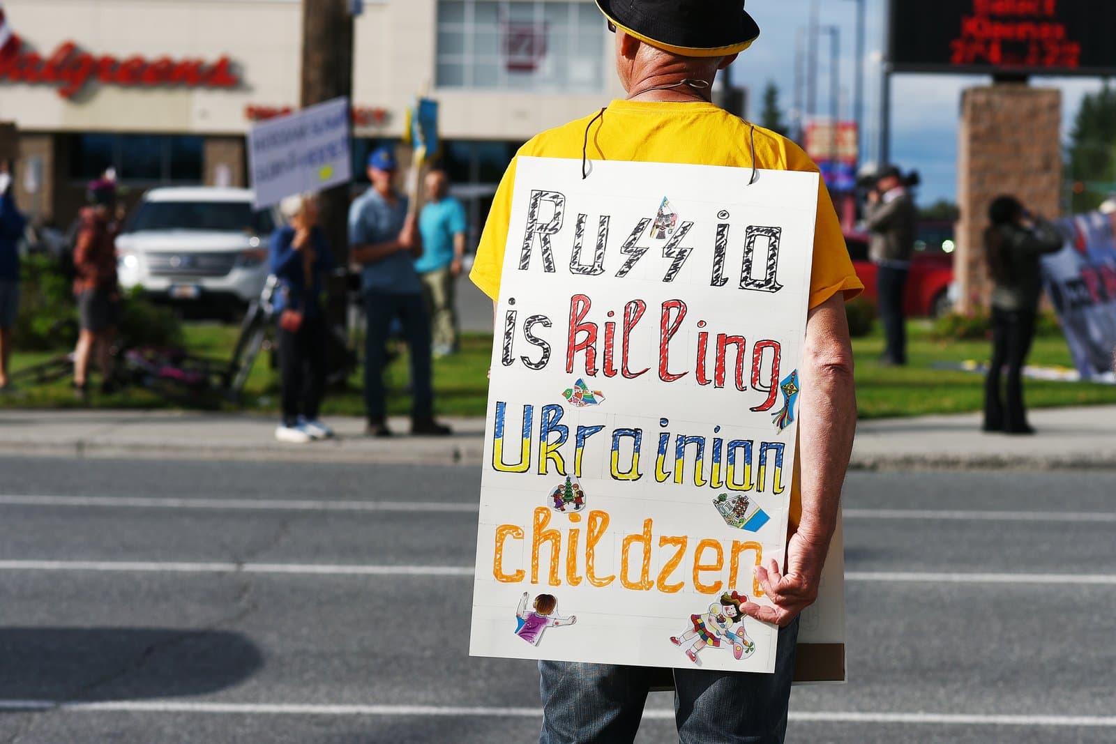 A protester stands in midtown Anchorage holding a handmade sign advocating for Ukraine during a public demonstration in August 2025.