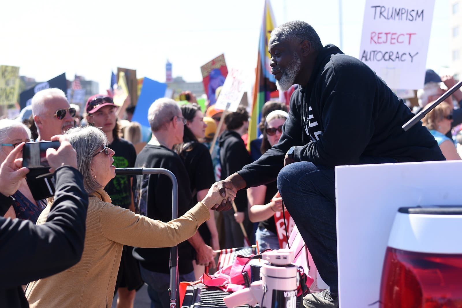 A man and a woman shake hands during a No Kings protest held in Anchorage, Alaska, on June 14, 2025.