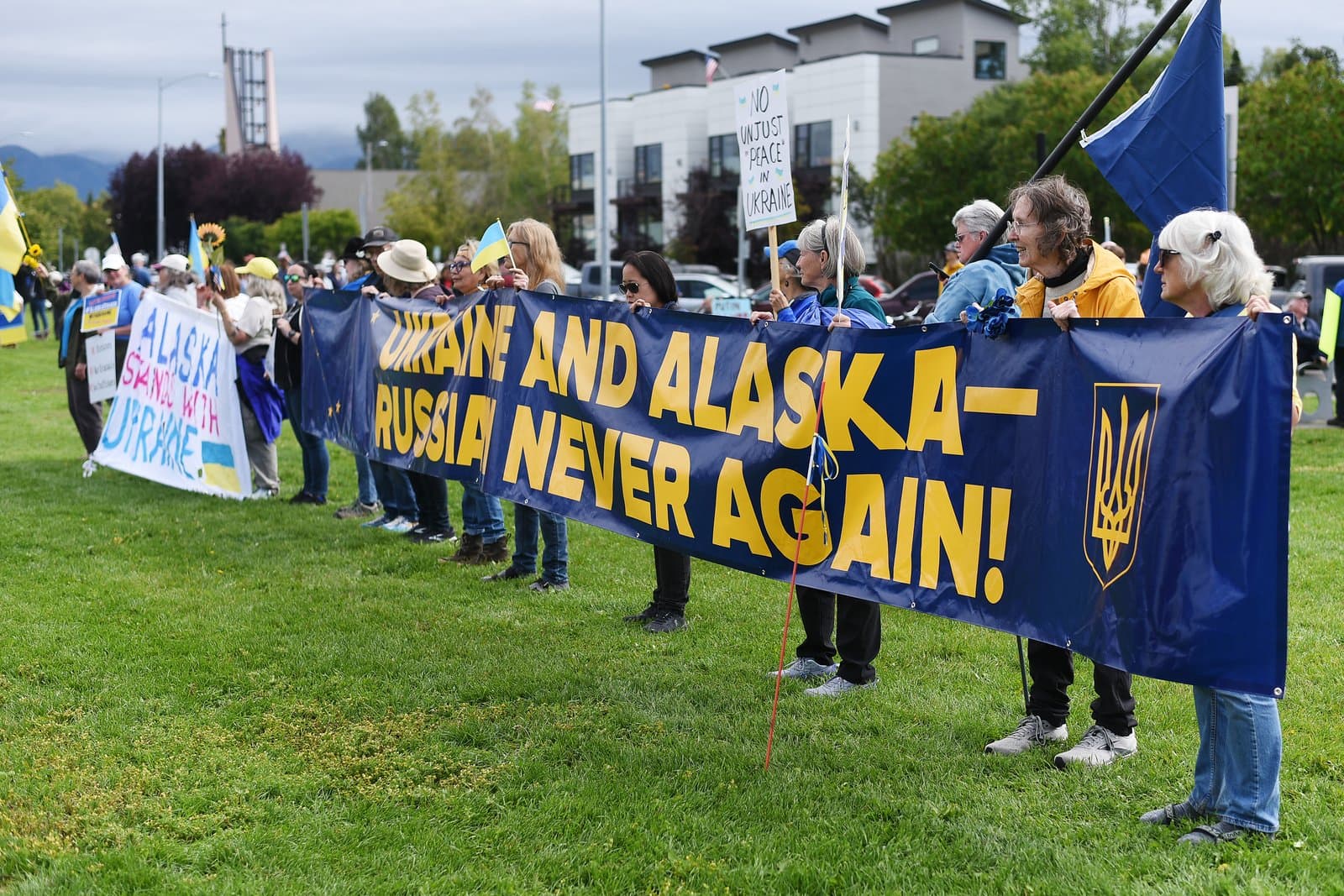 Protesters hold a large banner reading Ukraine and Alaska-Russia Never Again during a demonstration in downtown Anchorage on August 15, 2025.
