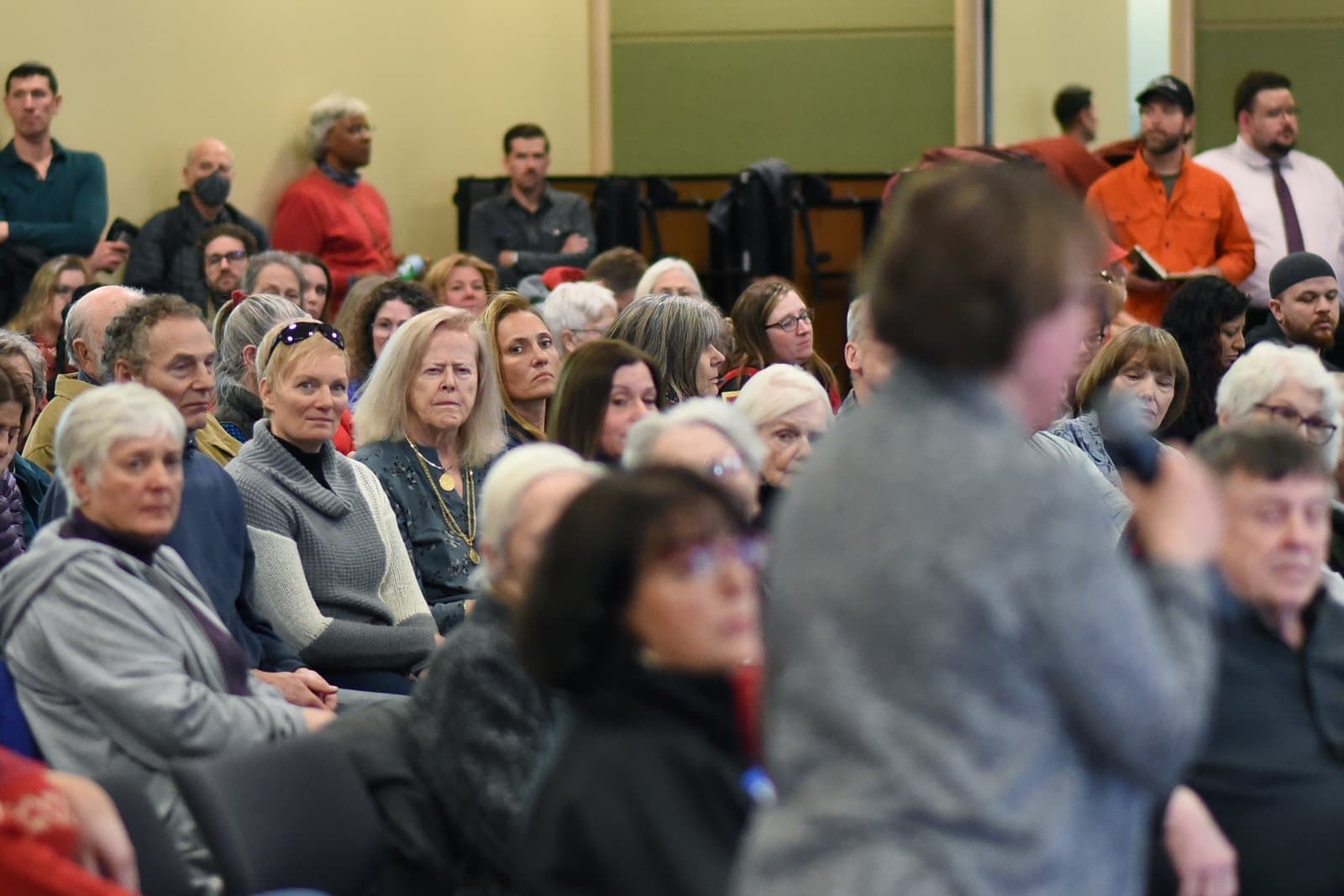 Attendees listen to a speaker during the 2024 Anchorage Legislative Town Hall held in an indoor community meeting space.