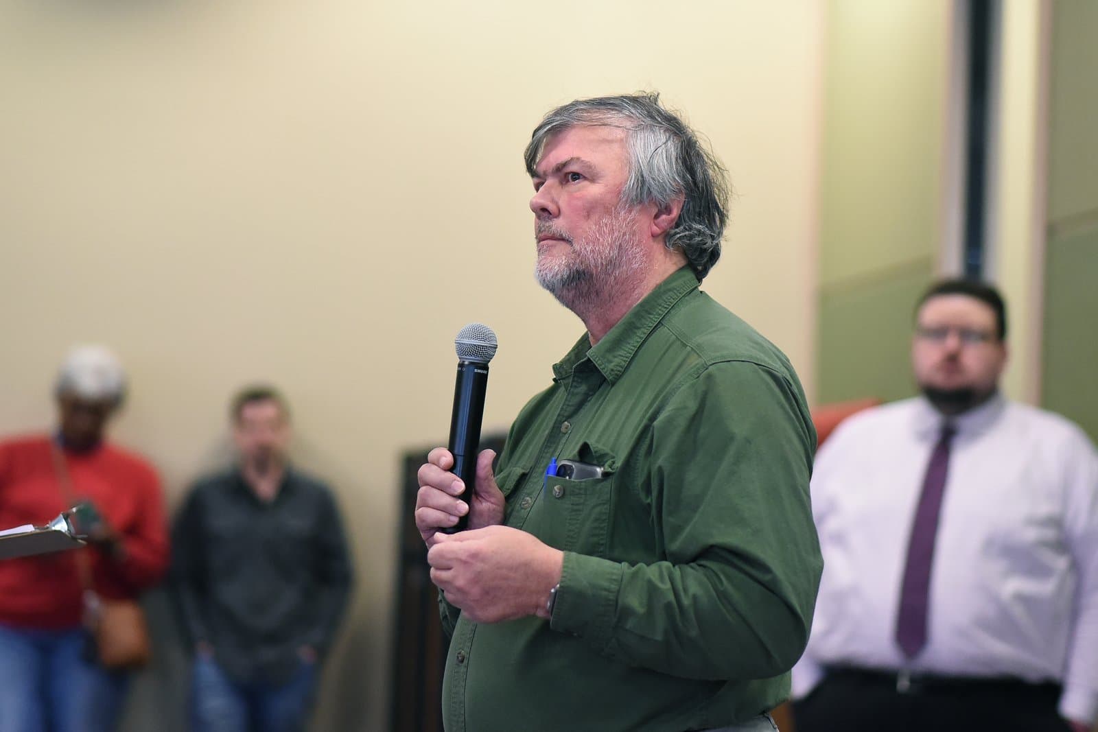 A man with graying hair speaks into a microphone during the 2024 Anchorage Legislative Town Hall held in Anchorage, Alaska.