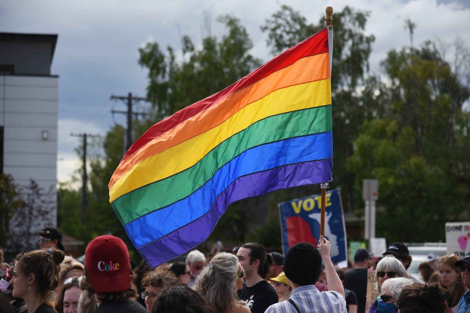A rainbow pride flag waves above a crowd of people during a Planned Parenthood rally in downtown Anchorage, Alaska, on July 9, 2022.