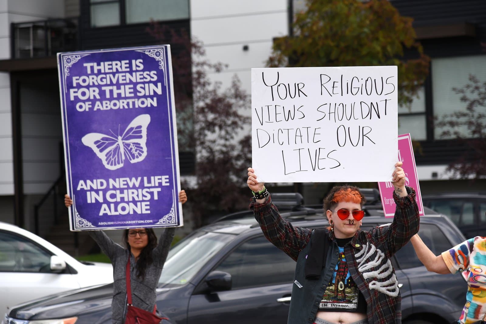 Protesters hold signs during a Planned Parenthood rally in downtown Anchorage, Alaska, on a summer day in July 2022.